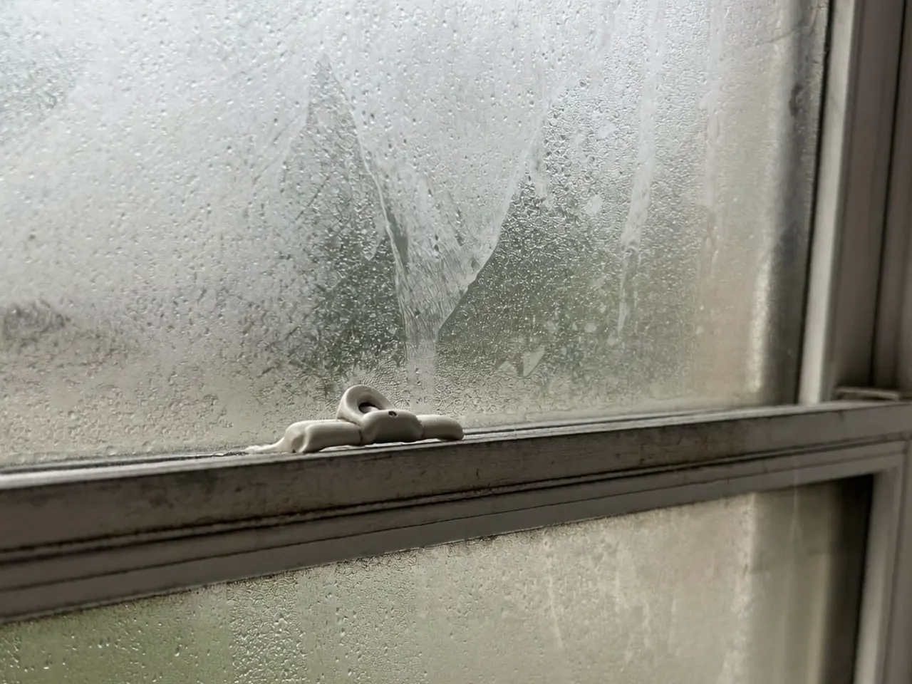 A blown double-glazed unit with a cloudy haze trapped between the two panes