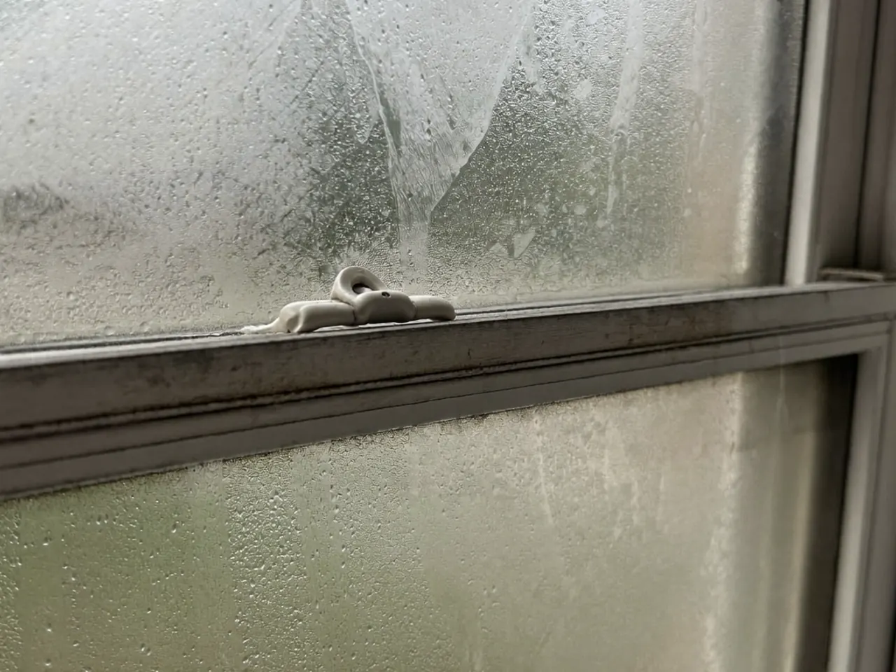 Moisture and cloudy haze trapped in the sealed cavity between two panes of glazing
