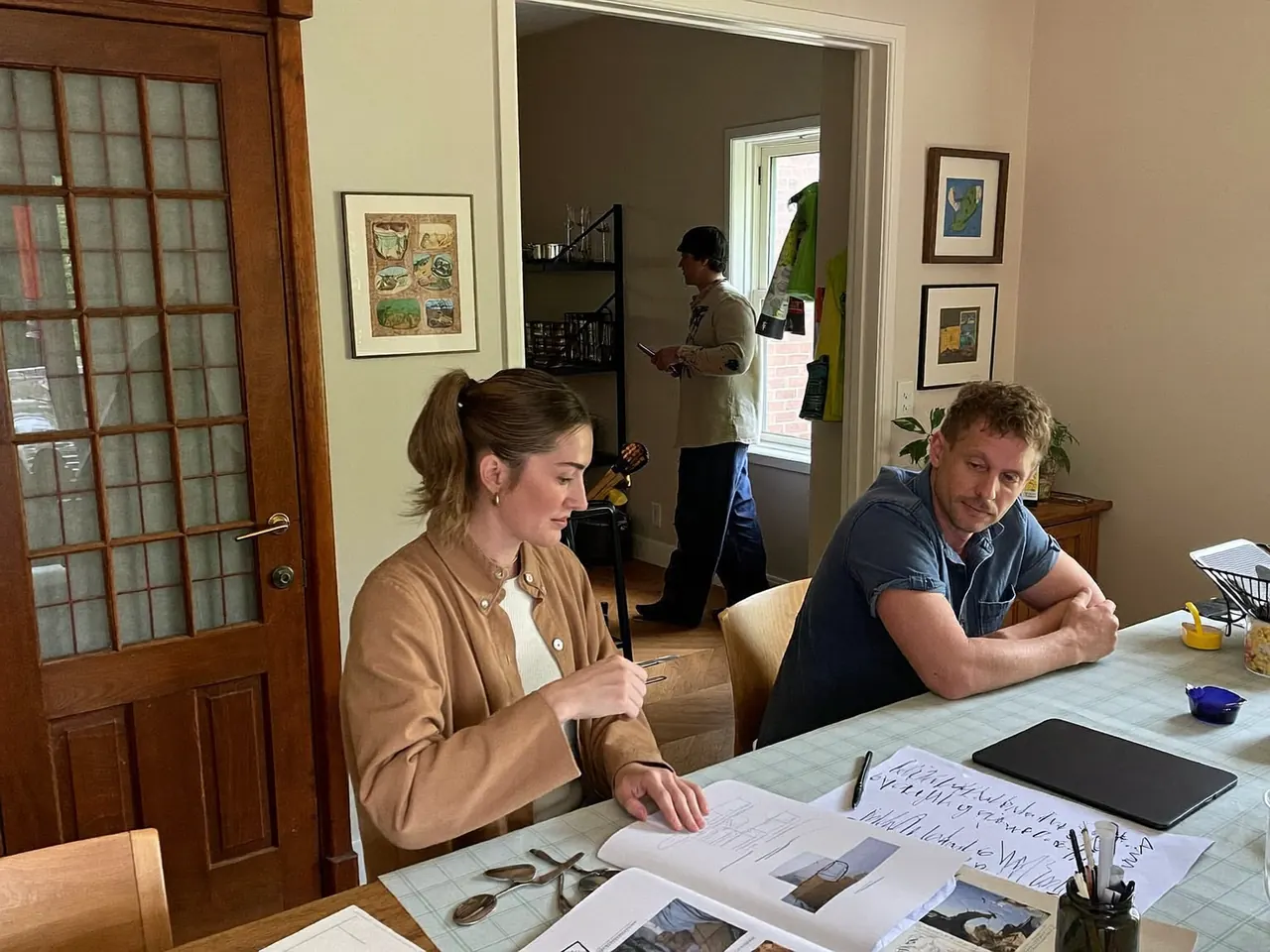 A homeowner and an installer discussing window options at a kitchen table